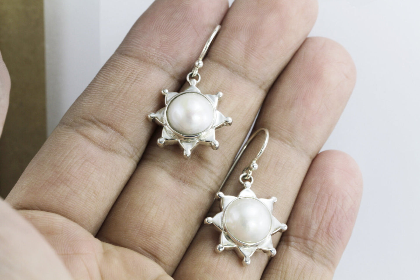 white mabe pearl earrings set in 925 sterling silver with star shape ornament