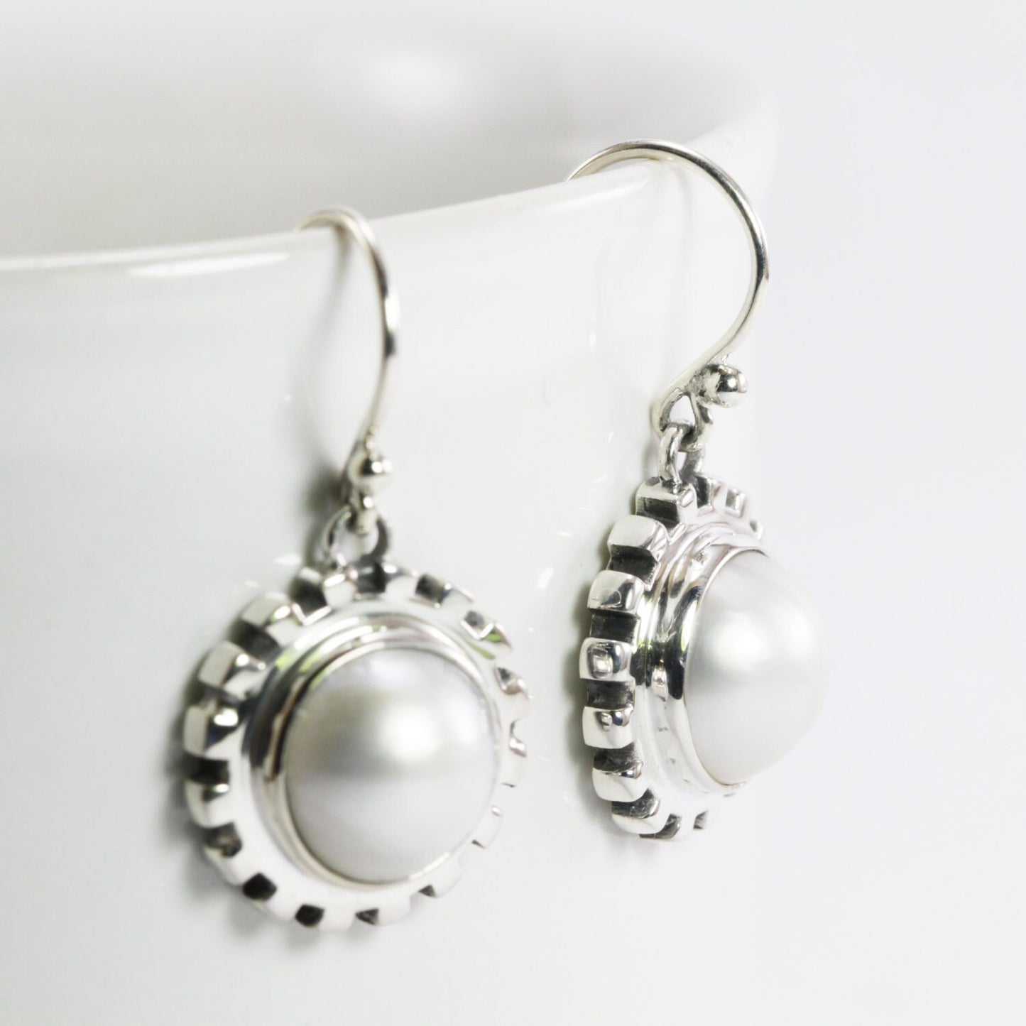 white mabe pearl earrings set in 925 sterling silver decorated with gear style ornament