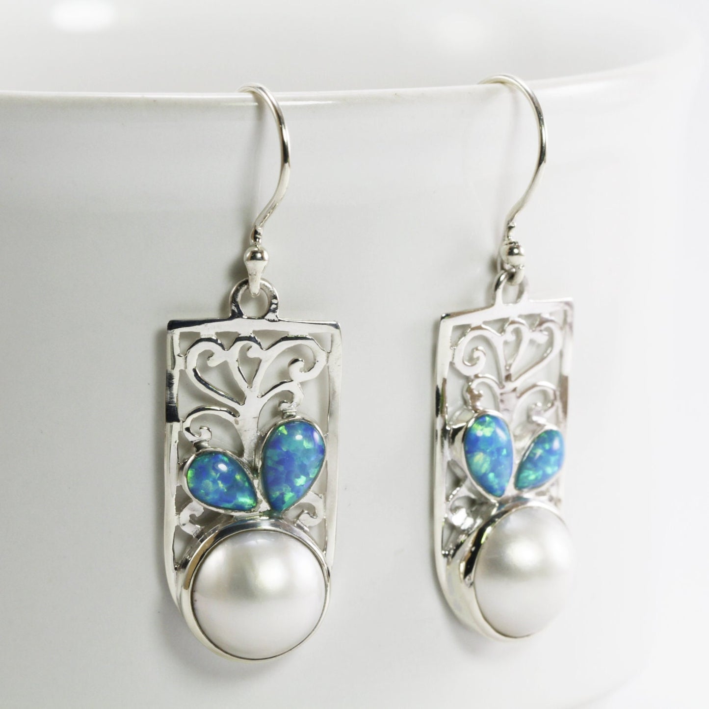 white mabe pearl earrings set in 925 sterling silver decorated with created opal and ornament filigree