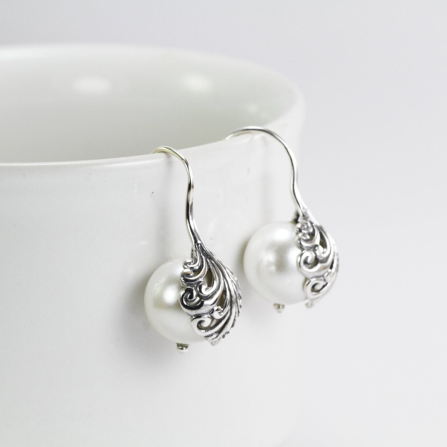 fresh water pearl earrings set in 925 sterling silver decorated with swirl filigree art