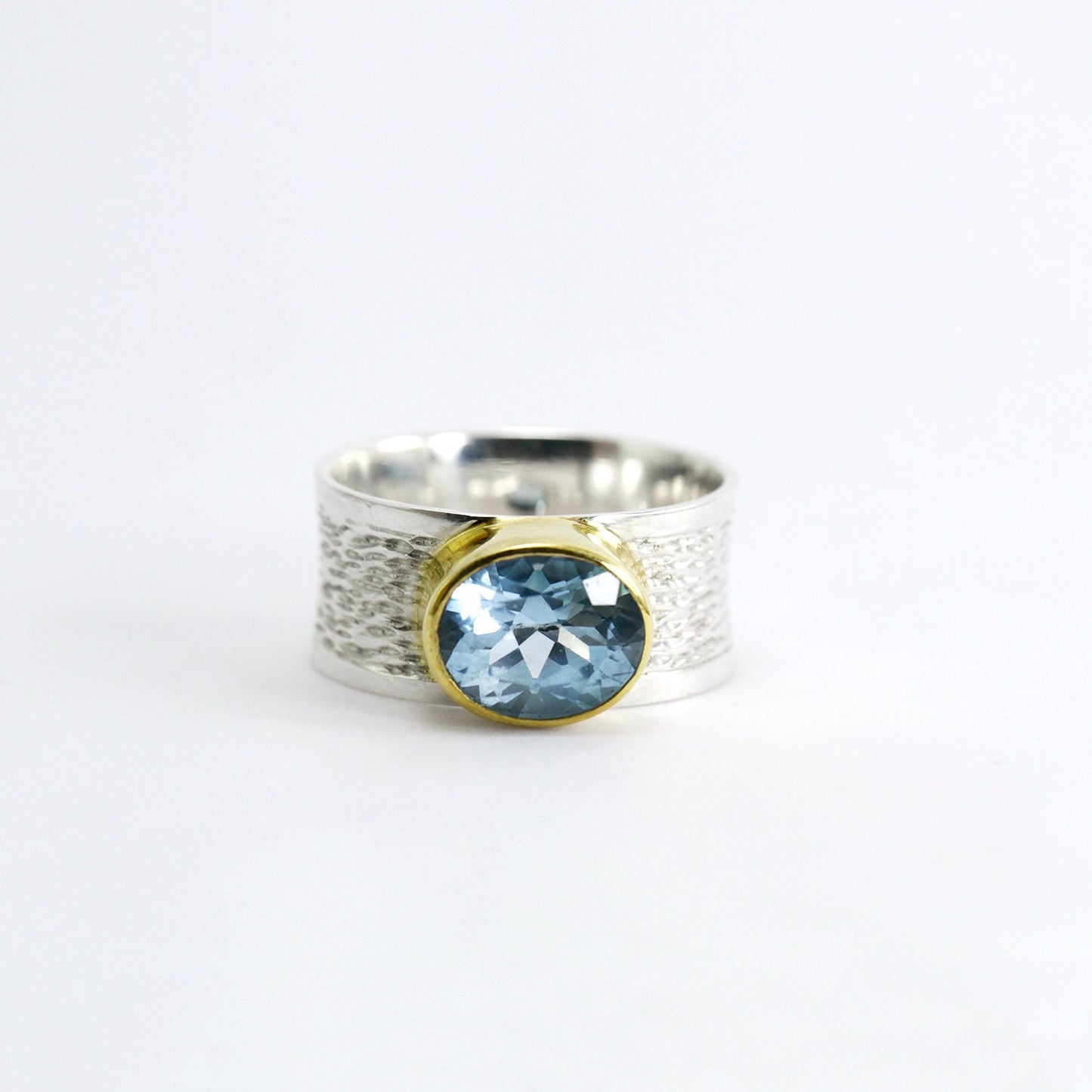 Wide band ring with genuine blue topaz decorated with gold vermeil