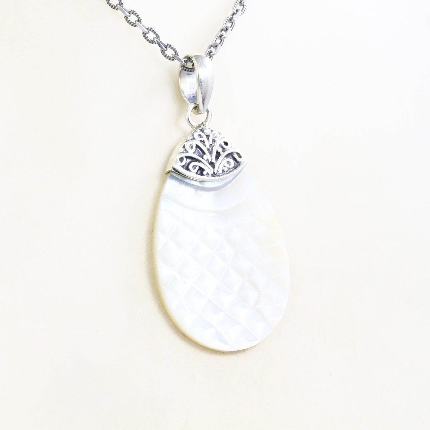 Tear drop pendant with genuine white shell set in 925 sterling silver decorated with Bali swirl filigree ornament