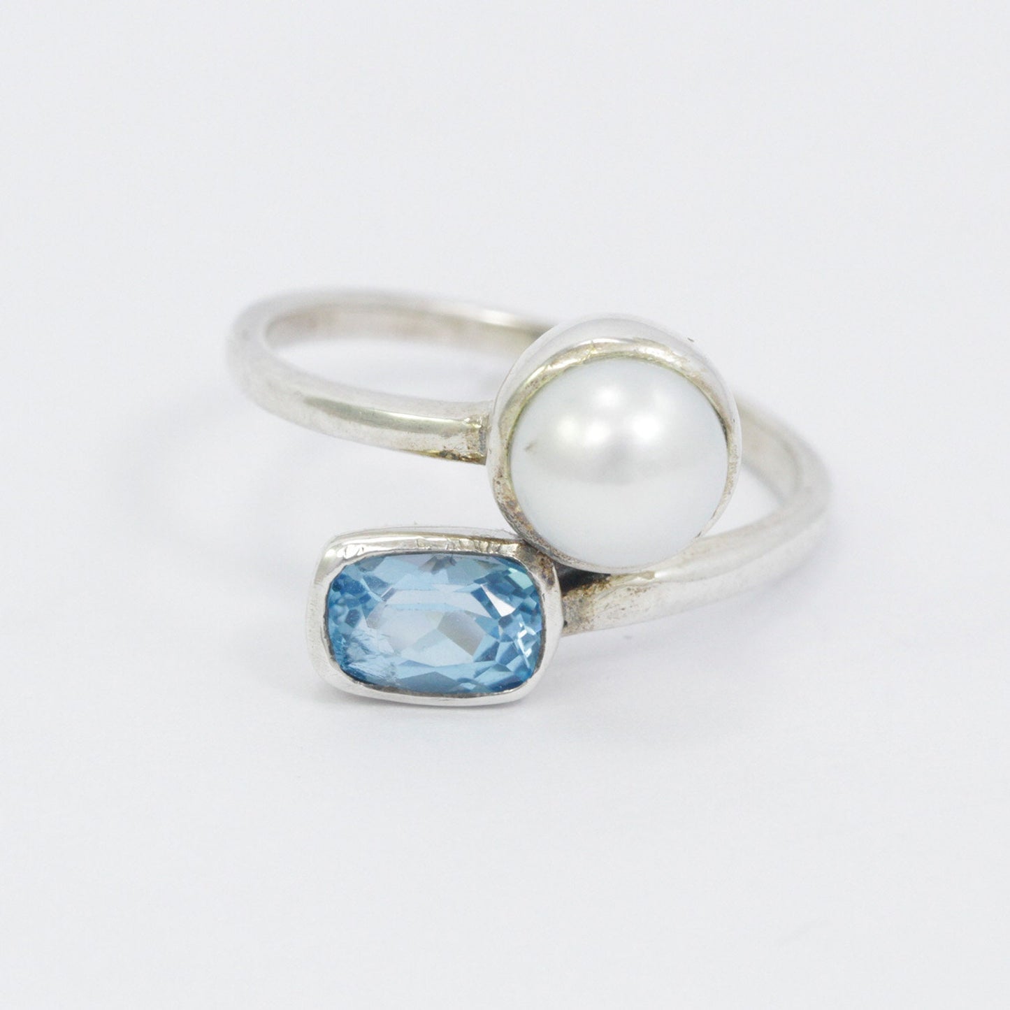 bypass ring with genuine blue topaz and freshwater pearl set in 925 sterling silver