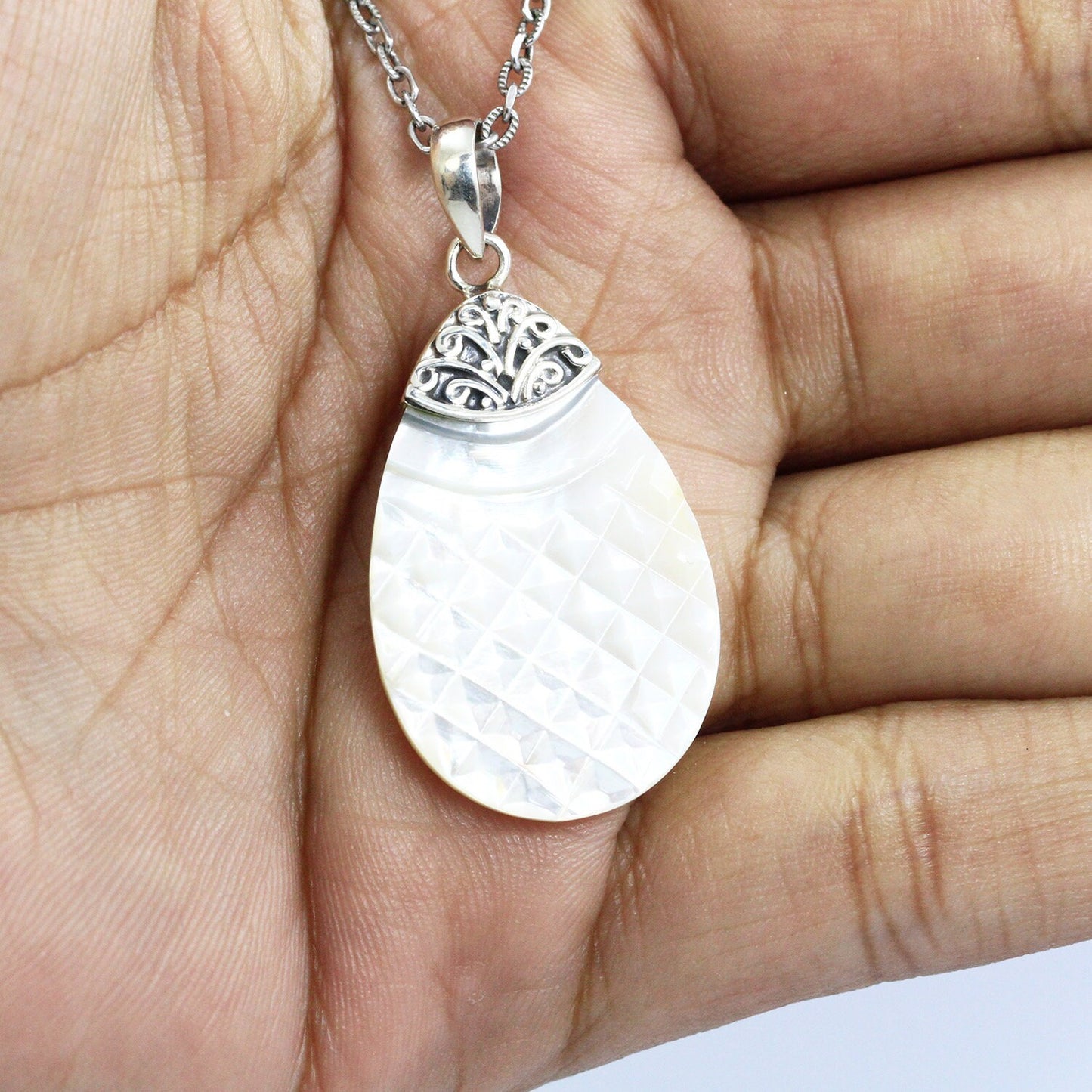 Tear drop pendant with genuine white shell set in 925 sterling silver decorated with Bali swirl filigree ornament