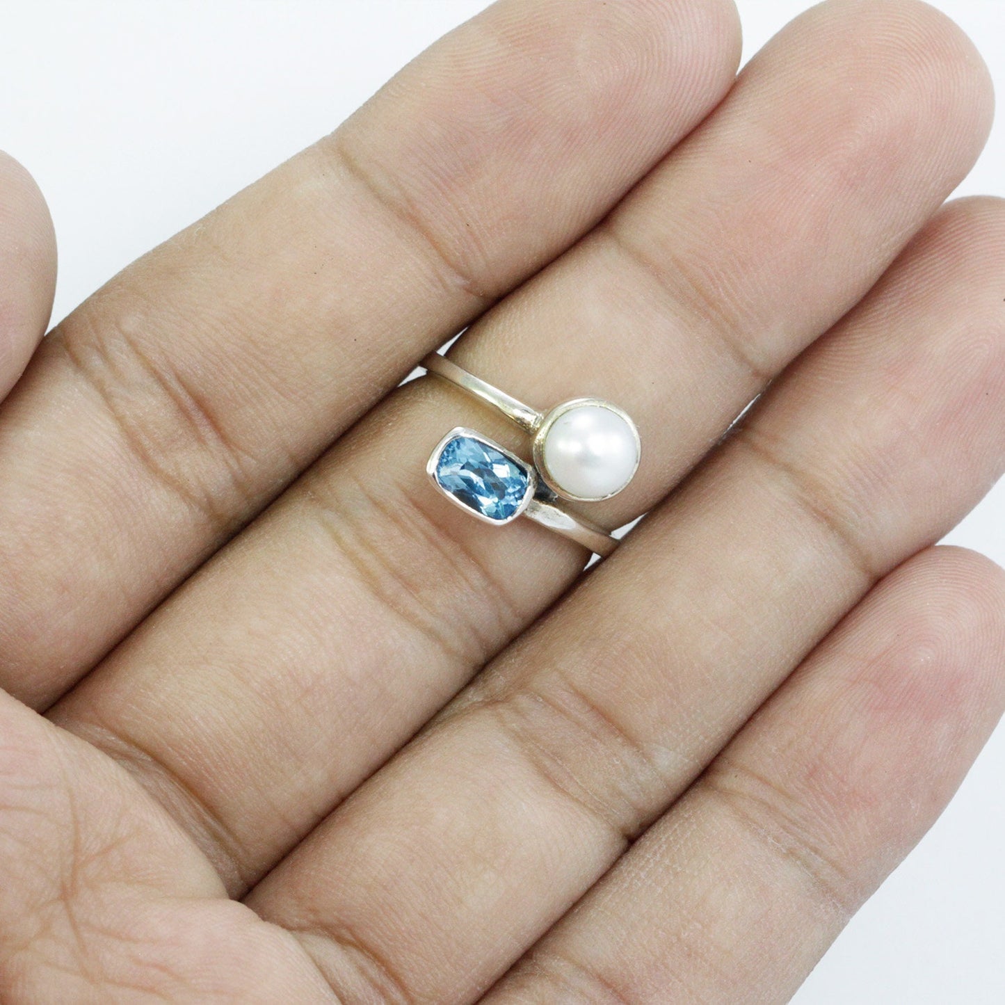 bypass ring with genuine blue topaz and freshwater pearl set in 925 sterling silver