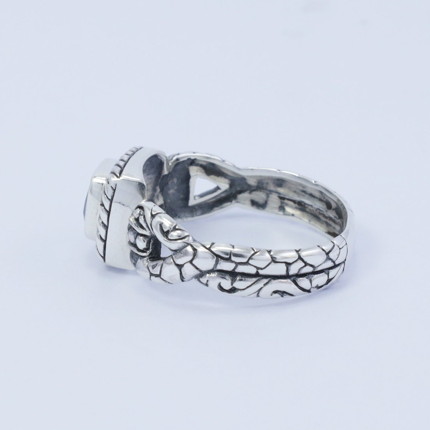 square ring with genuine blue topaz set in 925 sterling silver decorated with cable ornament