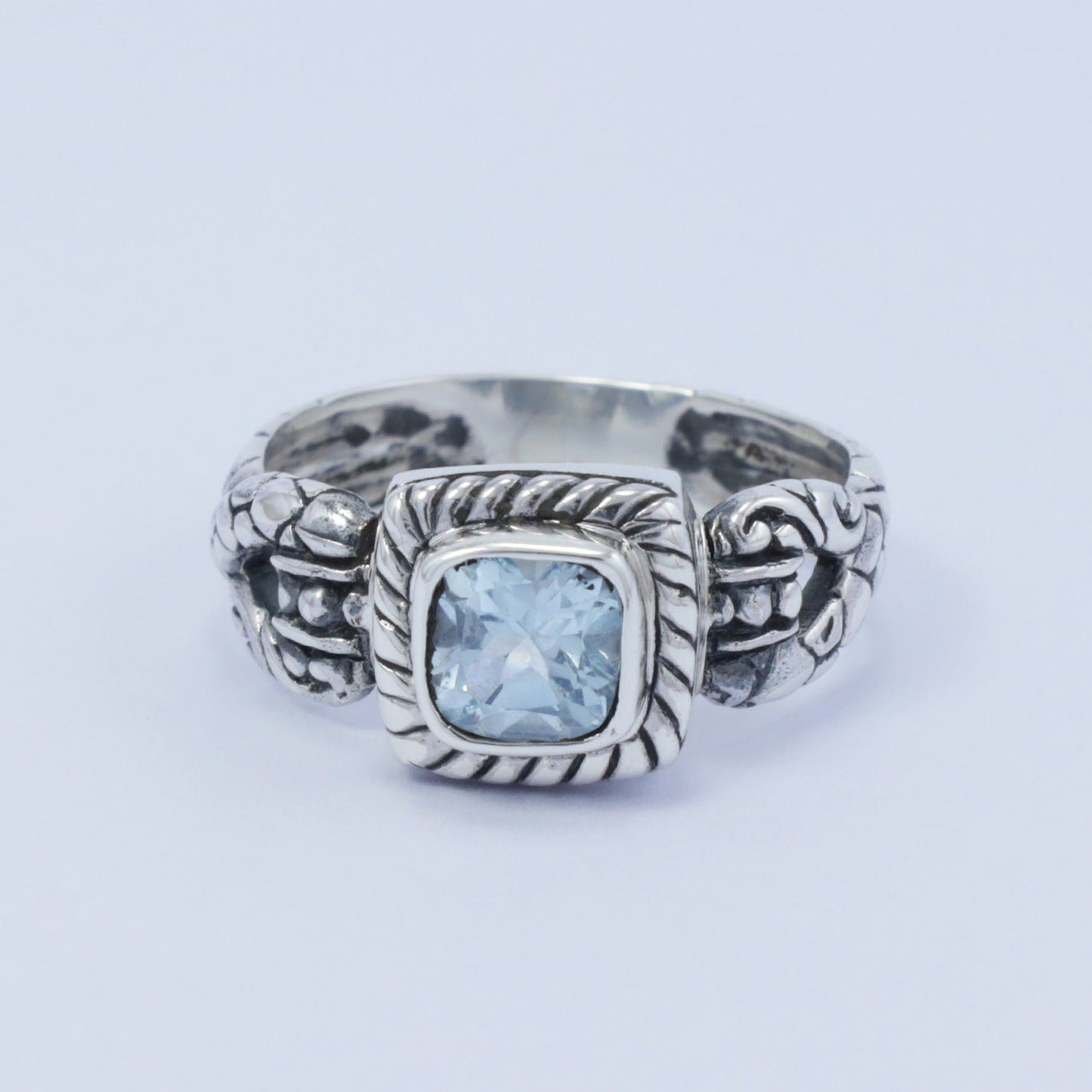 square ring with genuine blue topaz set in 925 sterling silver decorated with cable ornament
