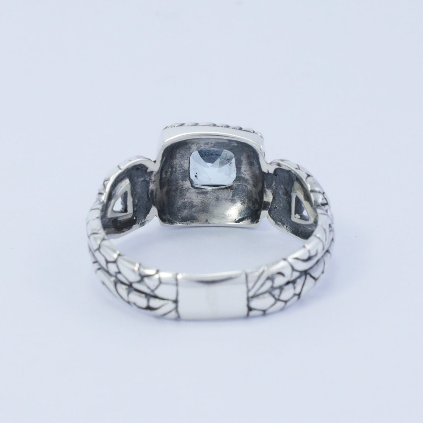 square ring with genuine blue topaz set in 925 sterling silver decorated with cable ornament