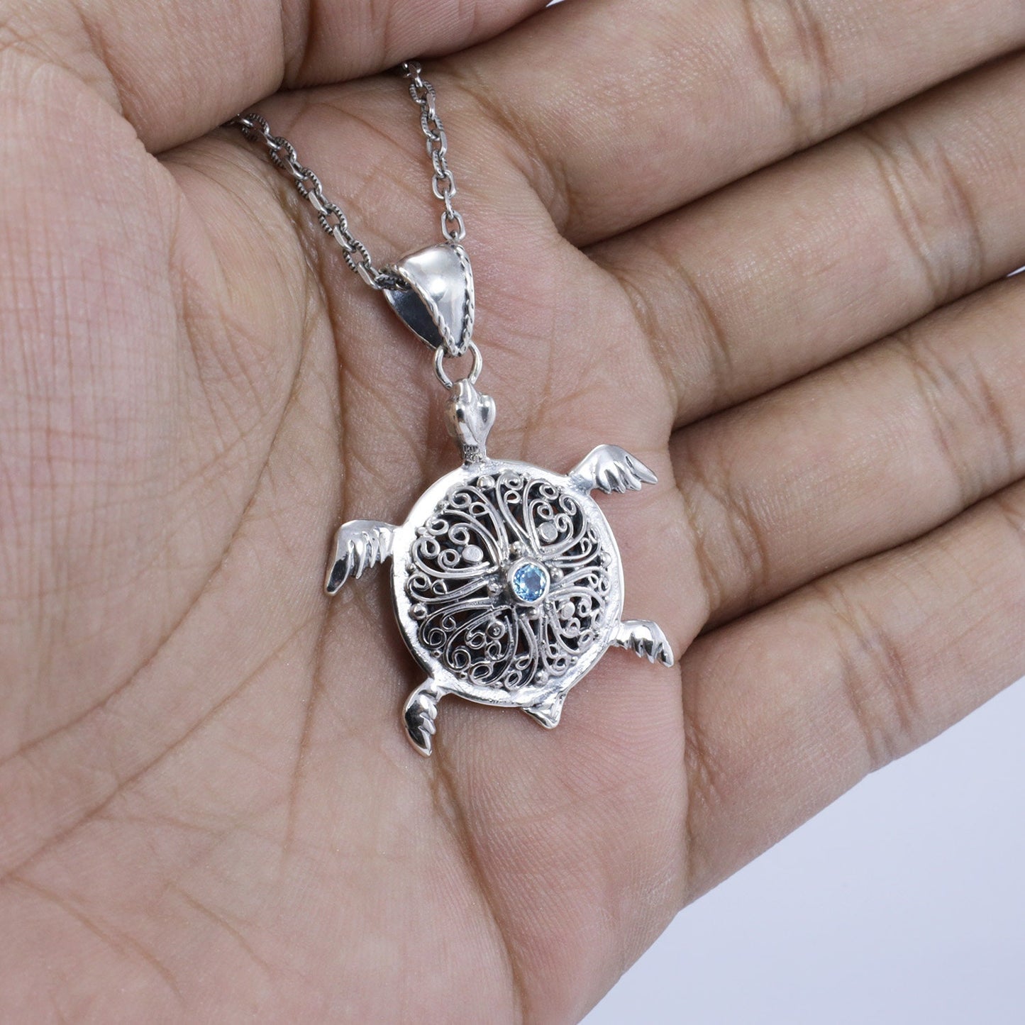silver turtle pendant necklace decorated with openwork filigree and genuine blue topaz