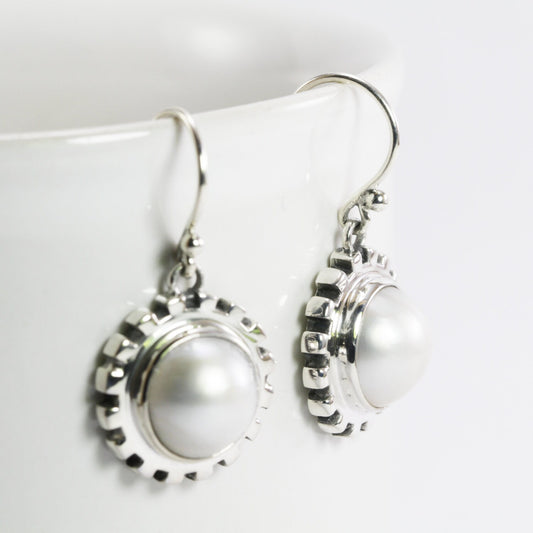 white mabe pearl earrings set in 925 sterling silver decorated with gear style ornament