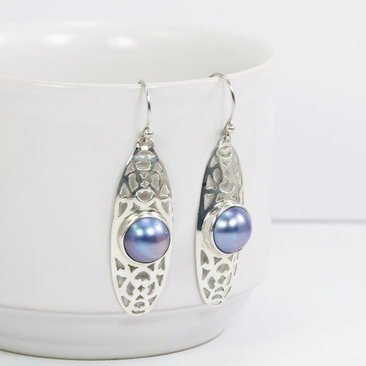 blue mabe pearl earrings set in 925 sterling silver decorated with open work ornament