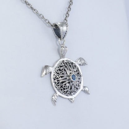 silver turtle pendant necklace decorated with openwork filigree and genuine blue topaz