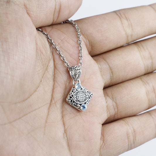925 sterling silver pendant decorated with Bali inspired ornament and genuine blue topaz